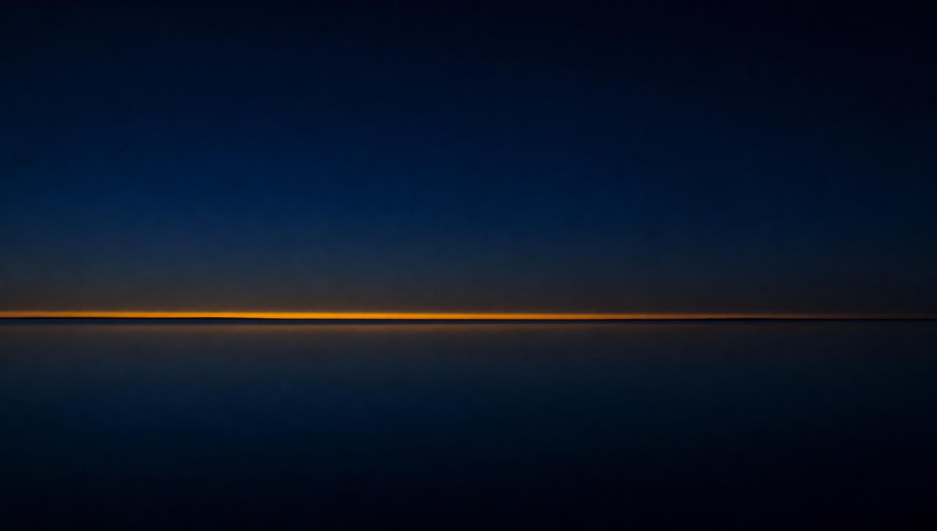 Still water at dusk with a single warm horizon line